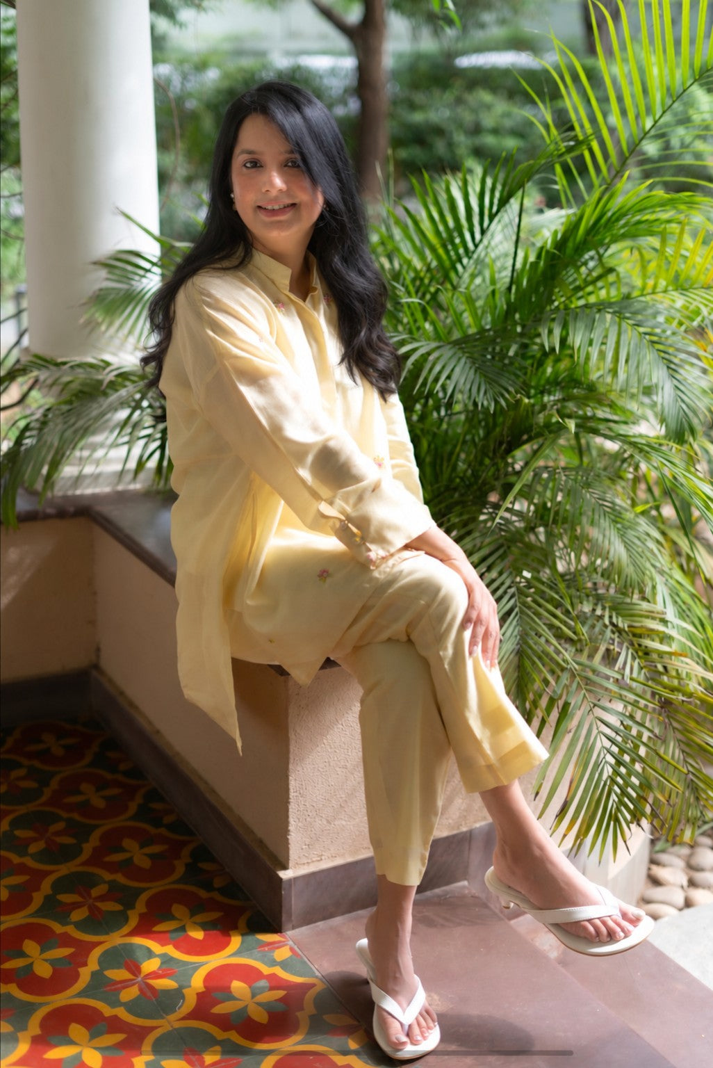 Nupur, founder of Bombay Brown, sitting in a light embroidered outfit