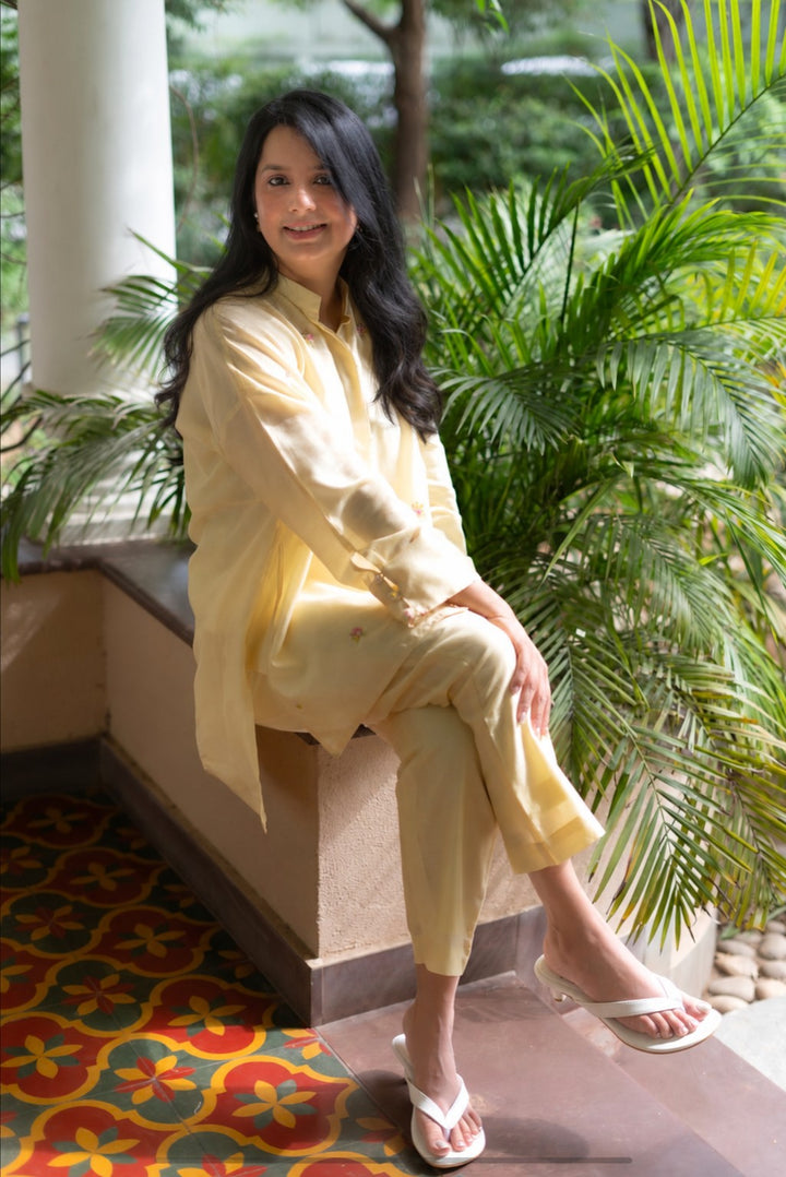 Nupur, founder of Bombay Brown, sitting in a light embroidered outfit