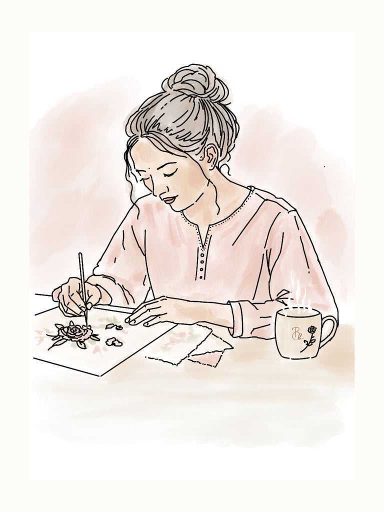 A floral embroidery idea being sketched at a drawing table